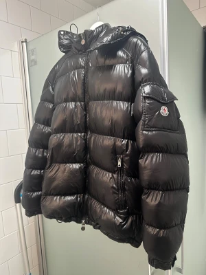 Moncler Maya jacka  - Moncler Maya jacka. Jackan är i mycket bra skick förutom att den har några små små hål vid axlarna men inget som syns knappt därav priset. Storlek 5 (storlek XL/L