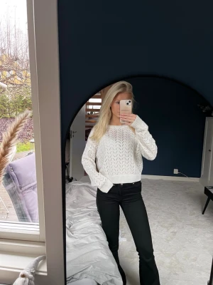 Vit stickad tröja med hålmönster - Säljer en vit stickad tröja med snyggt hålmönster och ribbade muddar. Supermjuk och passar till både höst och vinter.