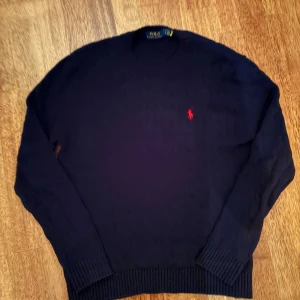 Mörkblå stickad tröja Polo Ralph Lauren - Snygg mörkblå stickad tröja från Polo Ralph Lauren. Pris kan diskuteras. Liten patch där bak eftersom de gick lite hål men märks inte