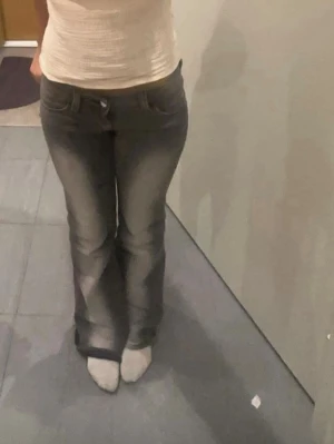 Grå bootcut jeans med låg midja - Säljer ett par grå jeans med snygg bootcut och låg midja. Storlek 27/32