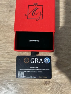 Ingen väst på bilderna - Bilderna visar en ring i en röd ask med certifikat från GRA, ingen väst syns på bilderna.