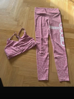 Aim’n träningsbyxa + sporttopp stl M  - Trendigt rosa träningsset med vita prickar, bestående av sport-bh och tights från Aim'n. Setet är gjort av polyester och spandex, storlek M. 