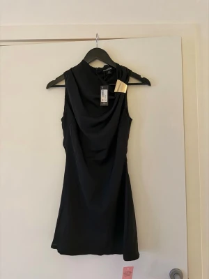 Svart kort klänning PrettyLittleThing - Svart kort klänning från PrettyLittleThing. Har aldrig använts, prislappen är fortfarande kvar. Storlek 32