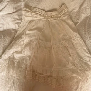 Kjol med spets - Vit kjol med spets som når en bit över knäskålarna. Kjolen saknar både märke och storlek, men jag skulle säga att den är en blandning av small och medium