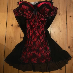 Svart och röd nattklänning Linea Donatella - Säljer en kort nightgown från Linea Donatella i svart och rött med spetsdetaljer och volangkant. Nattkläningen har justerbara axelband och transparent mesh på sidorna och ryggen. Super gullig och är i bra skick.