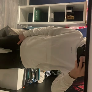 Vit hoodie från Calvin Klein Jeans XS - Säljer en stilren vit hoodie från Calvin Klein Jeans i storlek XS. Tröjan har fina detaljer vid huvan och bröstet. Den är sparsamt använd och storleken är Xs men är lite större så borde passa S