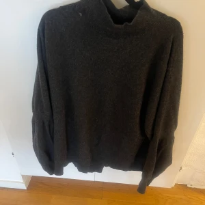 Mörkgrå stickad tröja Filippa K - Gråmelerad tröja från Filippa K Soft Sport. Tröjan har en hög krage som kan bäras på två sätt, antingen som en polokrage eller som en V-ringning. Tröjan är i fint skick. Storlek S. Rökfritt hem. Skickar paket som spårbart. 