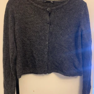 Mörkgrå kofta från 157, XS - Mysig mörkgrå kofta från 157 i storlek XS. Koftan har rund halsringning, långa ärmar och knäppning med flera knappar framtill. Perfekt att slänga över en topp för en chill look. 💗💗💗