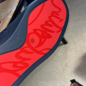 Blå mocka sneakers från Berluti - Snygga mörkblå sneakers från Berluti i lyxig mocka med rund tå och platt sula. Skorna har snörning och Berluti-logga broderad på hälen samt en röd sula med signaturdetalj. Insidan är i beige skinn för extra komfort.