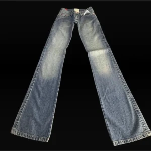 Snygga bootcut jeans blå, stl 24/34 - Snygga blå bootcut jeans från Replay med slitningar och ljusa partier. Klassisk femficksmodell med broderade detaljer på bakfickorna. Perfekt för dig som gillar en avslappnad och trendig look.