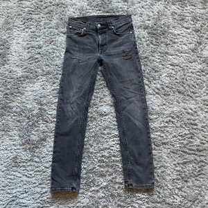 Nudie jeans med slitningar  - Nudie jeans med slitningar på framsidan storlek 27.28 men passar på större modell lean dean  