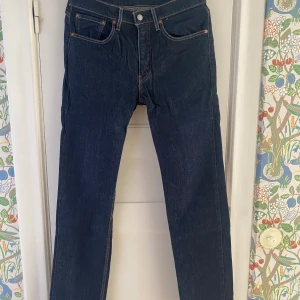 Levi's 514 mörkblå jeans W31 L34 - Mörkblå Levi's 514 jeans med klassisk femficksdesign och raka ben. Använda nån enstaka gång. Snygga kontrastsömmar och läderpatch bak i midjan. Jeansen är tillverkade i slitstarkt denim och har en normal passform som funkar till många stilar.