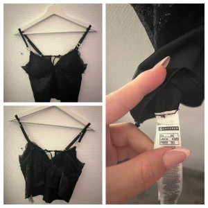 Svarta satinsleep-shorts med spets - Säljer ett par svarta satinsleep-shorts från Censored. De har elastisk midja, dekorativ spetskant och små rosetter på sidorna. En liten hjärtformad detalj framtill ger extra söt vibe. Perfekta för mysiga kvällar eller som loungewear.