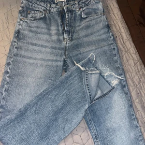 Gina tricot Jeans  - Snygga ljusblå jeans från Perfect Jeans med klassisk femficksdesign och slitna, fransiga detaljer vid bensluten. Jeansen har rak passform och är tillverkade i robust denim. Perfekt för dig som gillar en avslappnad och trendig look.