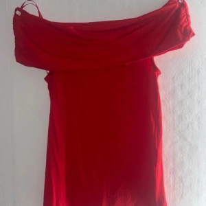 Röd offshoulder tröja Amisu XS - Röd tröja från New Yorker i offshoulder-modell. Använd 1 gång. Tillverkad i mjukt material som känns skönt mot huden. Perfekt för dig som vill sticka ut med en enkel men snygg look.