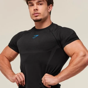 Svart Gymshark Onyx 5.0 seamless t-shirt - Svart Gymshark Onyx 5.0 seamless t-shirt med tight passform och korta ärmar. T-shirten har diskreta grå detaljer och blå Gymshark-logga på bröstet. Tillverkad i ett stretchigt syntetmaterial som andas, perfekt för träning och gym.