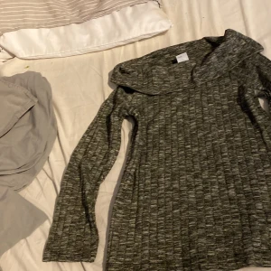 Grå ribbad tröja med stor krage Lindex - Mysig gråmelerad långärmad tröja från Lindex med bred, nedvikt krage. Tröjan är ribbad och har en cool struktur i tyget. Tillverkad i en mjuk mix av polyester, viskos och elastan som ger skön stretch och passform.