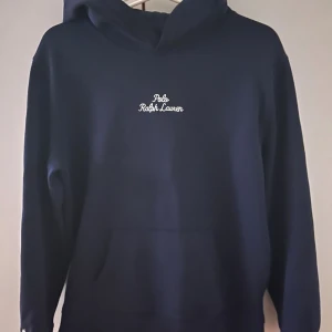 Marinblå hoodie från Ralph Lauren - Snygg marinblå hoodie från Ralph Lauren med vit broderad logga på bröstet. Tröjan är i Storlek S och passar för dig som är mellan 170-175! Tröjan är helt ny utan någon användning. Skriv i DM för ett vidare intresse eller fler bilder👍             Nypris: 1800kr