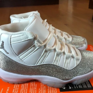 JORDAN 11 Metallic Silver  - Snygga par Jordans i vitt med glittriga silverdetaljer. 🤩Skorna har en hög modell med snörning och en ikonisk logga på sidan😁. Skorna är mer eller mindre oanvända bara använda ett få antal gånger, Perfekta för att sticka ut med oavsett vilken slags stil du har 🔥🔥🔥BÄTTRE PRIS VID SNABB AFFÄR!!! (för mer bilder bara att fråga) 