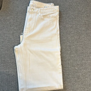 Vita jeans  - Snygga vita jeans från Zara med klassisk femficksdesign och rå kant vid benslut. Jeansen har en rak passform och är tillverkade i mjuk bomull med lite stretch för extra komfort. Perfekta för dig som gillar en clean och fräsch look.