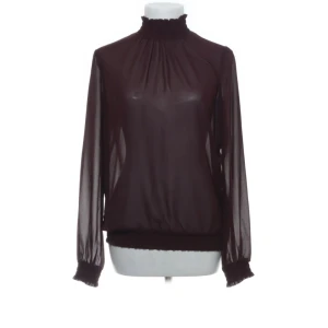 Vinröd  blus från Pieces - Säljer en vinröd transparent blus från Pieces i storlek XS. Blusen har långärmade puffiga ärmar, hög krage med volangkant och smockdetaljer vid hals och ärmslut. Perfekt till middagar eller tjejkvällar!