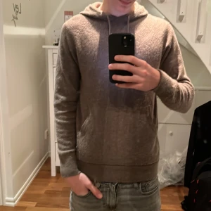 Beige Kashmir hoodie - Säljer en beige Kashmir hoodie med huva och magficka från märket scalpers. Tröjan har långa ärmar, ribbade muddar och en avslappnad passform. Perfekt för dig som gillar en enkel och stilren look. Passar lika bra till jeans som till mjukisbyxor. Storlek S sitter snäppet tajtare. Skick: mycket bra ina skador eller defekter.💯🙌
