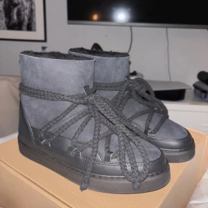 Svarta boots från Inuikii med snörning - Säljer ett par svarta Inuikii boots med grov snörning och rund tå. Utsidan är i mocka och skinn, insidan är fodrad med mjuk päls för extra värme. Sulan är platt och mönstrad för bra grepp. Helt oanvända då de va försmå!💘