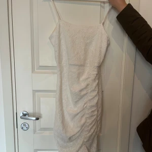 Vit spetsklänning från SHEIN - Superfin vit långklänning från SHEIN med smala axelband och spetsdetaljer. Klänningen har figurnära passform, rynkade detaljer på sidan och volang längst ner. Perfekt för sommarens alla tillfällen när du vill känna dig extra söt. Funkar även om man vill klä sig fint till något slags event. Jättegullig ! 