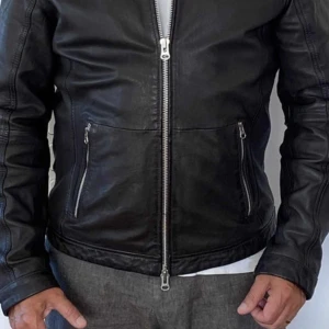 Mörkbrun skinnjacka från Human Scales  - Snygg mörkbrun skinnjacka från Human Scales i storlek L. Jackan har raka linjer, silverfärgad dragkedja framtill och två fickor med dragkedja. Fodret är i blankt blått tyg med innerficka, som ger en lyxig känsla. Perfekt för dig som vill ha en klassisk och stilren look och en jacka i mjukt läder. I nyskick, använd en gång! 