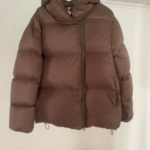 Brun pufferjacka Filippa K - Säljer min fina jacka från Filippa K.  Supervarm och skön vinterjacka. Färgen är brun/mörkgrön aktig färg.  Storlek S men passar även större och mindre beroende på hur man vill ha den!   Jackan har en liten fläck (se bild) men som knappt syns!   Nypris: 5999kr