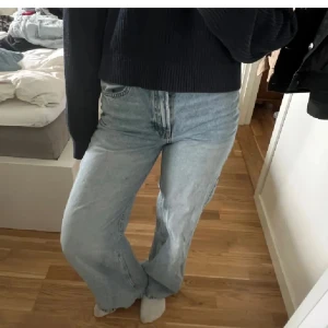 Ljusblåa wide jeans - Säljer ett par ljusblåa jeans med breda ben och hög midja. Jeansen har klassisk femficksdesign och är tillverkade i denim. Perfekta för en avslappnad och trendig look.