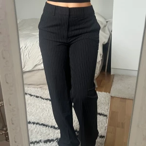 Svarta randiga kostymbyxor Madlady 🖤 - Snygga svarta kostymbyxor från Madlady med smala vita ränder. Storlek 34, längd short, passar dig som är lite kortare, ca 160-165cm. Byxorna är midwaist, raka ben och klassiska fickor fram. Perfekt för dig som gillar en stilren och trendig look. Modell Erin. Fint skick 🖤