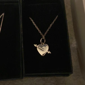 Hjärthalsband med pil - Säljer detta snygga silverfärgade hjärthalsband som har en pil genom sig och med ingraverad söm över hjärtat. Köpte från alvazessentials 💘 Längd 45-50 cm