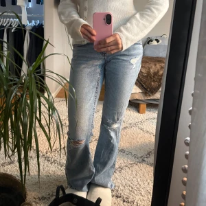Bootcut ljusblå jeans med slitningar - Säljer ett par ljusblå bootcut jeans med snygga slitningar och hål på knäna. Dom är i storlek 164 men sitter som en XS/S. 💕Jeansen är uppsprättade (skriv om du vill ha närmare bild)