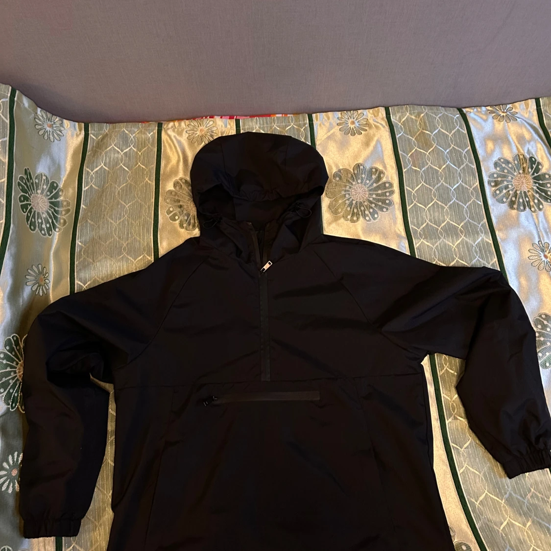 Svart vindjacka med huva och half zip