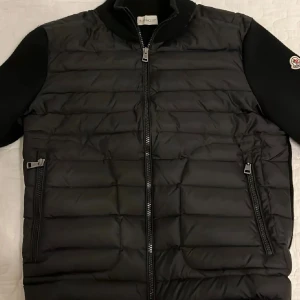 Svart moncler cardigan - Svart moncler cardigan. Nfc tag funkar. Bra skicka. Använd i cirka 2 år, köpt på plick.