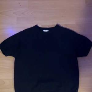 Marinblå stickad tröja Gina Tricot - En marinblå stickad tröja från Gina Tricot i storlek 158/164. Tröjan har rund hals och korta ärmar, perfekt för dig som gillar enkel och stilren design. Materialet är mjukt och ger en skön känsla mot huden. Passar dig som vill ha en klassisk look.