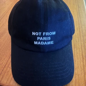 Drôle de Monsieur keps - Snygg Drôle de monsieur med ”Not from Paris madame2 som text. Köpt på nk för 950. Skicket är som nytt, har bara använt den någon fåtal gång. KVITTO FINNS!