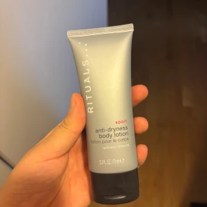 Rituals Sport Body Lotion 70ml - Rituals Sport anti-dryness body lotion med aktivt kol, 70 ml. Tuben är grå med svart lock och har en modern, sportig design. Innehåller 95% ingredienser av naturligt ursprung och är framtagen för att återfukta och revitalisera huden. Helt ny aldrig använd 