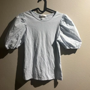 Blå T-shirt med puff armar  - Tröja från hm med puff armar, väldigt bra skick och super fin ljusblå färg. Hör av er vid frågor❣️köparen står för frakten