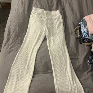 Vita ribbade byxor från Gina Tricot - Säljer ett par vita ribbade byxor från Gina Tricot i storlek S. De har raka ben och en bekväm passform som är perfekt för en chill och stilren look.