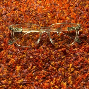 Chrome heart glasögon med silverdetaljer - Snygga chrome heart glasögon med rektangulär form och coola silverblommor på bågens sidor. Ramen är i klar plast och har en modern vibe med unika metallblommor som ger extra edge. Perfekt för dig som vill sticka ut med din stil.