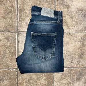 Replay jeans  - Mörkblå Repaly Wallys jeans med skinny passform. Jeansen har coola slitningar och kontrastsömmar, samt en diskret logotyp på bakfickan. OBS Storlek 16 år, bedömer att de sitter som W30 L30 men utgå ifrån måtten. Midja 32cm, längd 99cm. JAG SKICKAR EJ FLER BILDER NÄR JAG BÄR JEANSEN! för storleksguide hänvisar jag till måtten och för bättre inblick i passformen rekommenderar jag att googla på modellnamnet. Jeansen kan vara uppsydda utan att jag noterat det så kolla måtten noggrant :) s4