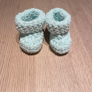 Ljusgröna virkade babytossor - Supergulliga ljusgröna virkade babytossor i mjukt garn. Är perfekta för små fötter. Tossorna är fluffiga och har en mysig känsla, perfekta för att hålla värmen under kyliga dagar. Mäter ca 9 cm