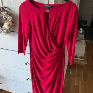 Röd omlottklänning från Ralph Lauren - Snygg röd omlottklänning från Ralph Lauren med draperad midja och trekvartsärm. Använd 1 gång -storlek xs/s