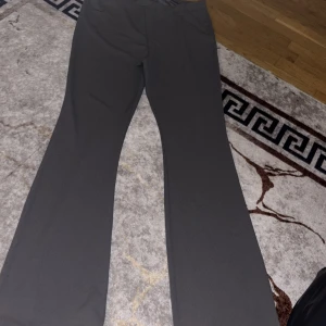 Svarta bootcut byxor - Säljer ett par svarta bootcut byxor med snyggt utsvängda ben. Byxorna har en enkel och stilren design, perfekta att matcha med olika toppar. Materialet känns mjukt och stretchigt för en bekväm passform.