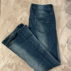 Gina 14+ jeans - Snygga mörkblå jeans med klassisk femficksdesign och utsvängda ben. Jeansen har en lätt tvättad look med ljusare partier framtill och baktill. HELT SLUTSÅLDA!