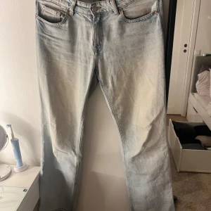 Hm jeans - Säljer ett par klassiska ljusblå Hm jeans med raka ben och femficksmodell. Jeansen har en snygg tvättad look och är tillverkade i robust denim. Perfekta för dig som gillar en tidlös och avslappnad stil.