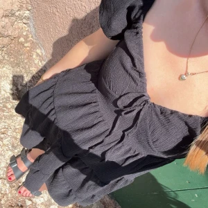 Svart klänning Gina Tricot - Säljer en svart klänning i storlek S från Gina Tricot. Den har diskreta puffärmar, en snörning vid bysten och en fin kjol. Den är i mycket bra skick. Hör gärna av dig vid frågor🤎