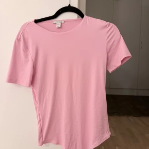 Rosa kortärmad body - Snygg rosa kortärmad body från New Yorker i storlek L. Överdelen har en rund hals och korta ärmar. Aldrig använd 